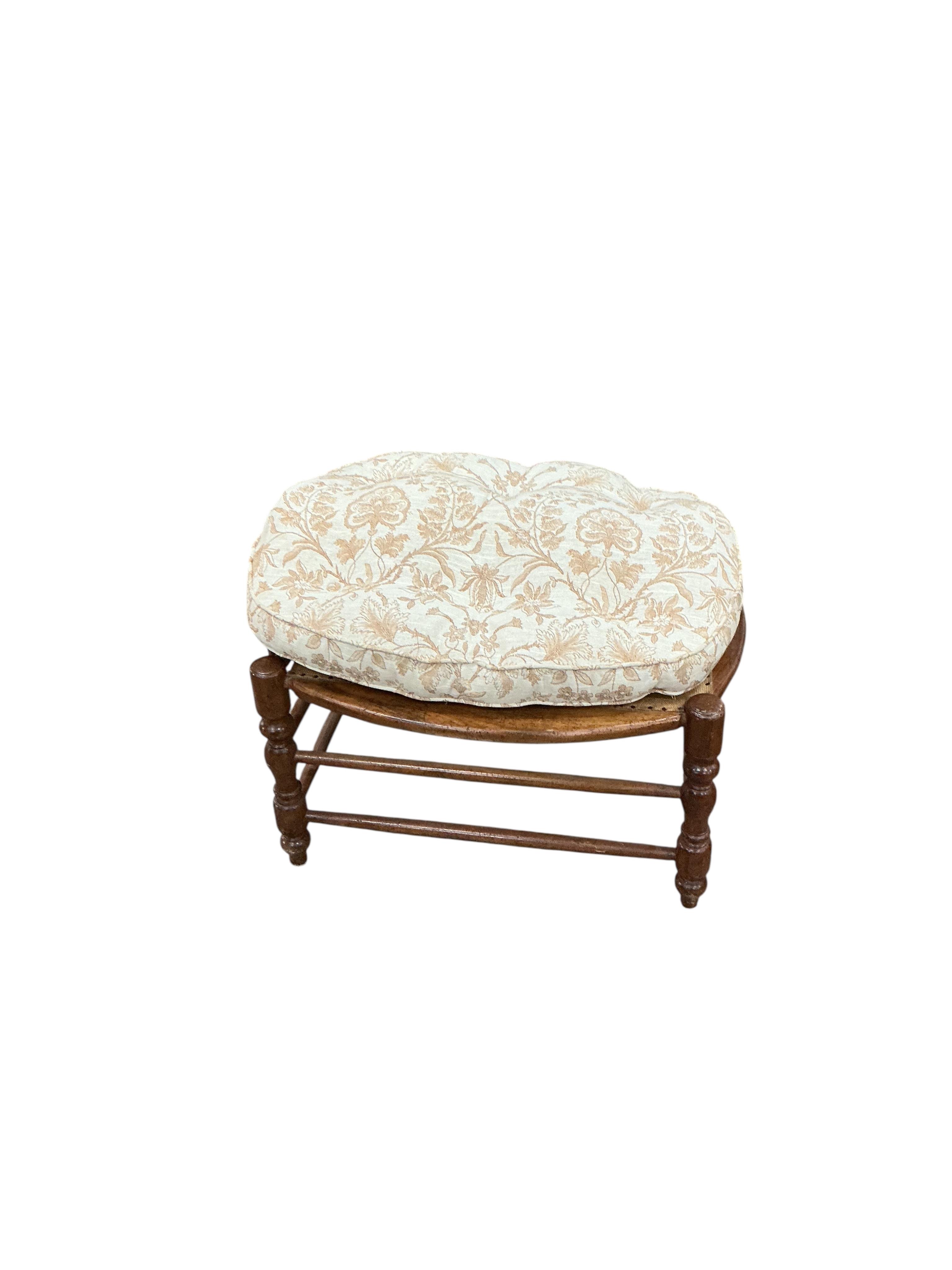 A 19th century French fruitwood armchair, width 70cm, depth 64cm, height 112cm and foot stool